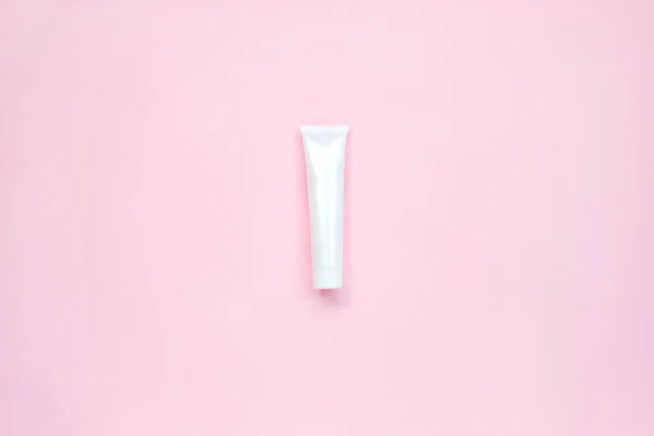 Tubo de plástico brillante blanco para medicina o cosméticos, crema, gel, cuidado de la piel, pasta de dientes sobre fondo rosa pastel. Belleza cosmética tubo — Foto de Stock