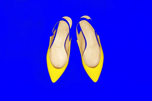 Zapatos de moda amarillo glamour sobre fondo de neón azul. Mínimo. Arte brillante estilo colorido. Dama de la fiesta brillante de lujo. plano laico . —  Fotos de Stock