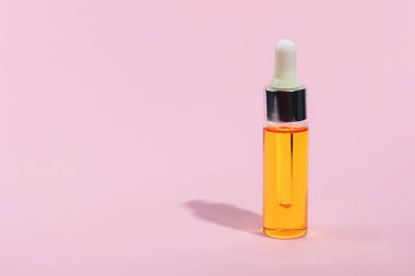 Damlalık cam Şişe Mock-Up. Pembe arka plan, afiş veya şablon serum cilt bakım kozmetik. Güzellik ürün konsepti.