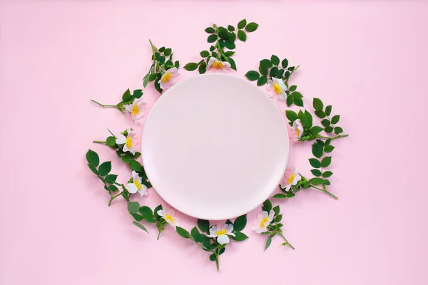 Renkli parlak çiçek kompozisyon. Pembeye yapılmış çerçeve çiçekler ve pastel pembe arka planda pembe plaka etrafında Leafs gül. Düz yatıyordu, kopya alanı.