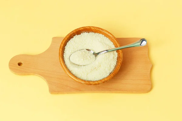 Collagen protein in the bowl and spoon - Hydrolyzed on yellow background