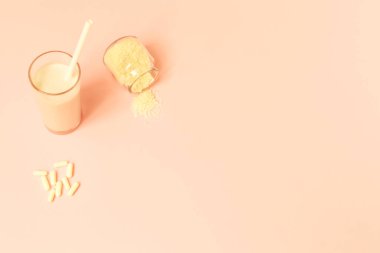 Collagen powder, milk and pills on pink background. clipart