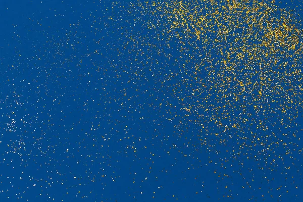 Gouden glitter op blauwe achtergrond. Vakantie abstracte textuur — Stockfoto