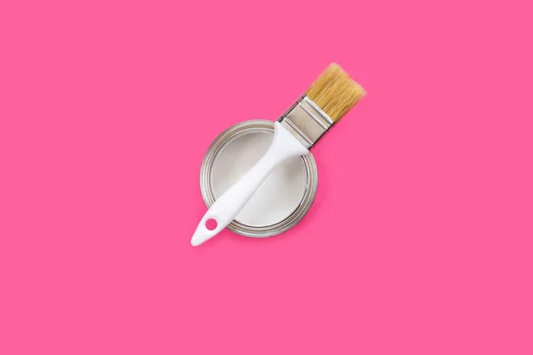 Lata abierta con pintura blanca y pincel sobre fondo rosa . — Foto de Stock