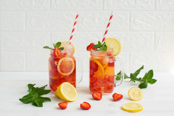 Cold strawberry lemonade juice with ice cubes, lemon and mint. — Stock Photo, Image