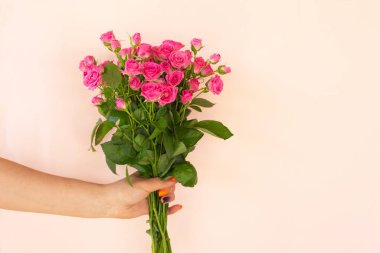 Kızın elleri açık arkaplanda pembe gül buketi tutuyor. Kopya alanı. Doğum günü, Anneler, Sevgililer Günü, Kadınlar, Düğün Günü konsepti.