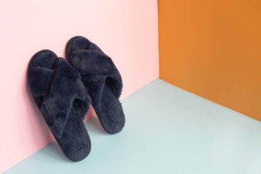 Renkli arka planda mavi ev terlikleri. Yukarıdan bak. Seçici odak.