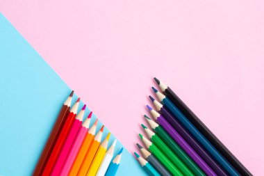 Mavi ve pembe arka planda renkli kalemler. Okul ve ofis aksesuarları. Okul konsepti. düz yatay üst görünüm kopyalama alanı