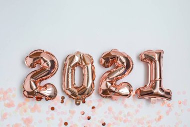 Folyo balonları 2021 numaralı formda ve konfeti hafif arka planda. Düz yatıyordu. Yeni yıl kutlaması. Tatil partisi dekorasyonu.