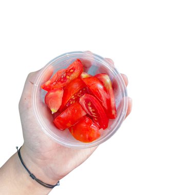 İçinde taze domates dilimleri olan el ele tutuşma kasesinin üst görüntüsü. beyaz üzerine izole