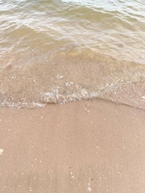 Kumlu sahilde yumuşak bir mavi okyanus dalgası. Arkaplan.