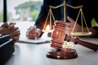 İş kadını ve avukatlar, ofisindeki ahşap masada pirinç tartı ile sözleşme belgelerini tartışıyorlar. Hukuk, hukuk hizmetleri, tavsiye, Adalet kavramı.