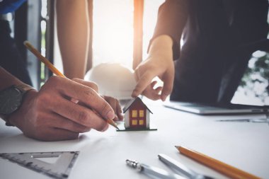 Mimari planın pusula ve planlarıyla çalışan iki mimar adam danışmanı, bir inşaat projesi konsepti çiziyor..