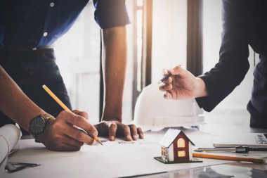 İki mimar adam ve onun plan ve mimari plan, bir inşaat proje kavram çizim mühendisi için planları ile çalışan kadın.