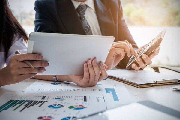 Business People Meeting Design Ideas Concept. Group of Investor diverse brainstorm using calculator and Digital tablet on wooden desk.