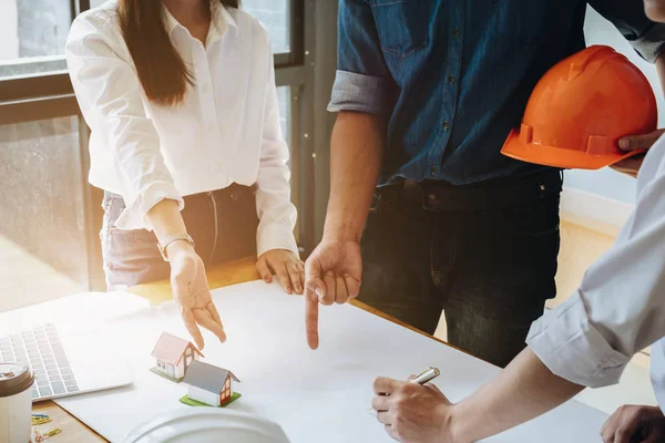 Mimarlık ekibi ofiste planı işaret ediyor ve birlikte çalışıyorlar. Mimar takım konsepti.