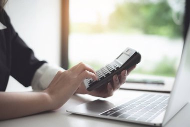 Matematik finansmanı için hesap makinesi ve dizüstü bilgisayar kullanan iş kadını ofis ve iş geçmişinde, vergi, muhasebe, istatistik ve analitik araştırma kavramında kapat