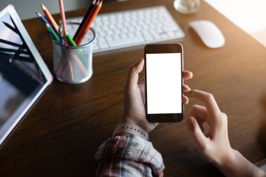 Kapat Kadın eli Evde boş ekranlı bir cep telefonu kullanarak.