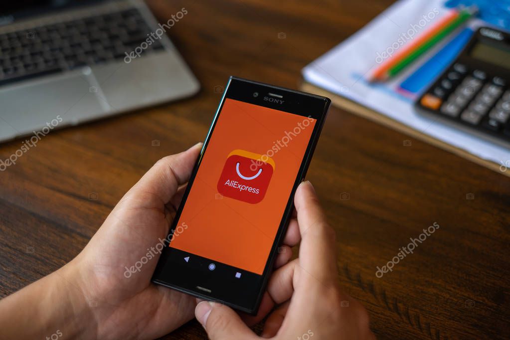 CHIANG MAI, THAILAND : JULY 09,2018 : A man holding Phone with Aliexpress application icon. AliExpress is e-commerce application from china.