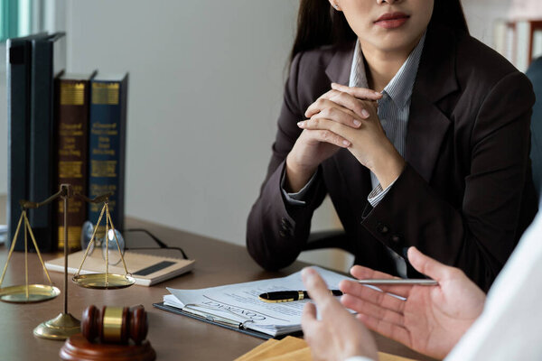 A lawyer and client focus on contract terms during a professional meeting, highlighting the importance of legal clarity.