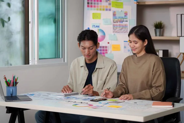 İki genç profesyonel birlikte UX UI tasarım oturumuna katıldı, modern bir çalışma alanı üzerine beyin fırtınası ve çizim fikirleri.