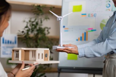 İki profesyonel, sürdürülebilir kalkınma projelerinde, modelleri sergilemede ve modern bir ofiste ESG stratejilerini tartışmada işbirliği yapmaktadır..