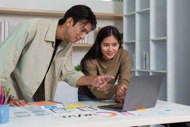 İki tasarımcı bir dizüstü bilgisayarda UX UI tasarımı, takım çalışması ve yenilikçi düşünce üzerine bir tartışmaya girdiler..