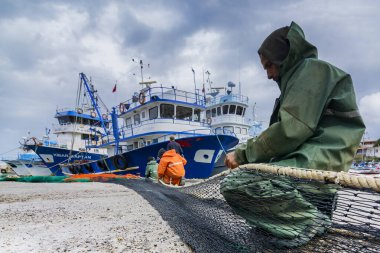 Ağları tamir eden bir balıkçı.