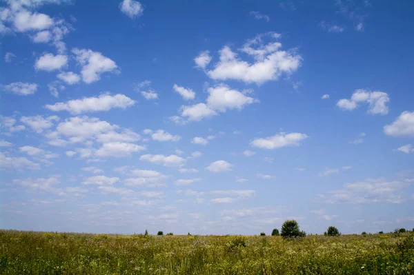 Wolken am blauen Himmel über landwirtschaftlichen Feldern — Stockfoto