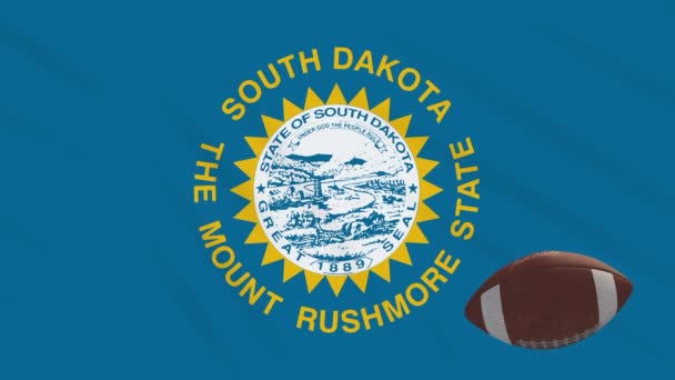 South Dakota flag waving and american football ball rotates, loop — Stock Video