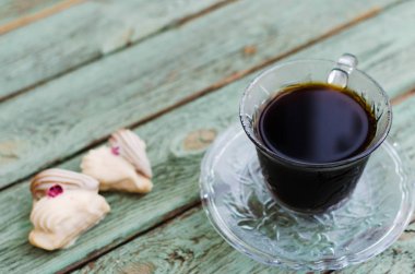 Eski turkuaz ahşap tahta üzerinde kurabiyeyle kahve.