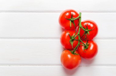 Beyaz ahşap zemin üzerinde domates şube. Yakın çekim. Seçici odak.