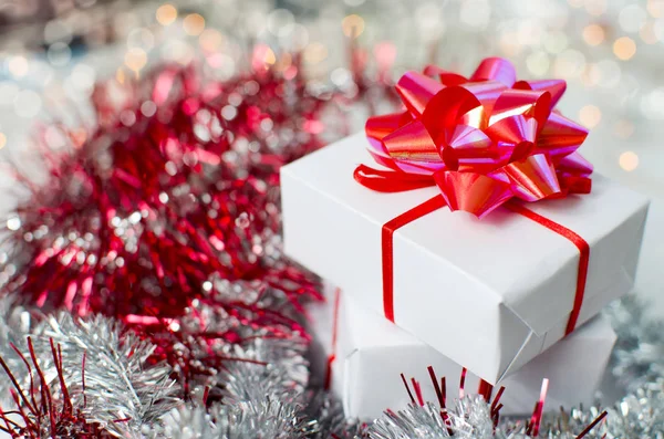 Новорічна подарункова коробка з червоними стрічками на білому столі та прикрасою . — стокове фото