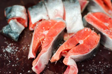 Rustik masada tuz ile taze çiğ somon biftek. Seçici odak.