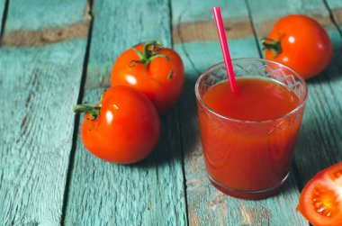 Taze domates ve tuz ile bardak domates suyu. Rustik ahşap arka plan. Seçici odak.