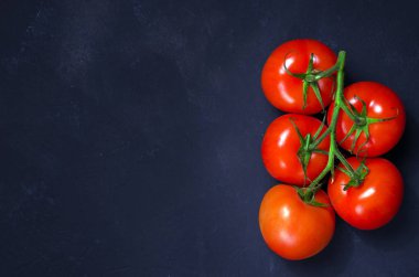 Olgun kırmızı domates karanlık taş zemin üzerine. Kopya alanı.