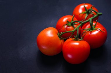 Olgun kırmızı domates karanlık taş zemin üzerine. Uzay kopyalayın. Seçici odak.