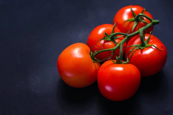 Olgun kırmızı domates karanlık taş zemin üzerine. Uzay kopyalayın. Seçici odak.