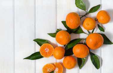 Meyve taze mandarin portakal veya mandalina ahşap masa üzerinde bir sepet içinde yapraklarla