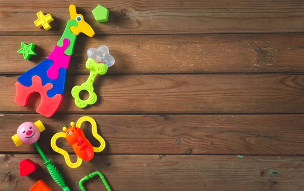 Üstten görünüm veya düz renkli oyuncaklar kopya alanı ile koyu ahşap arka plan üzerinde yatıyordu. Sıcak vintage filtre