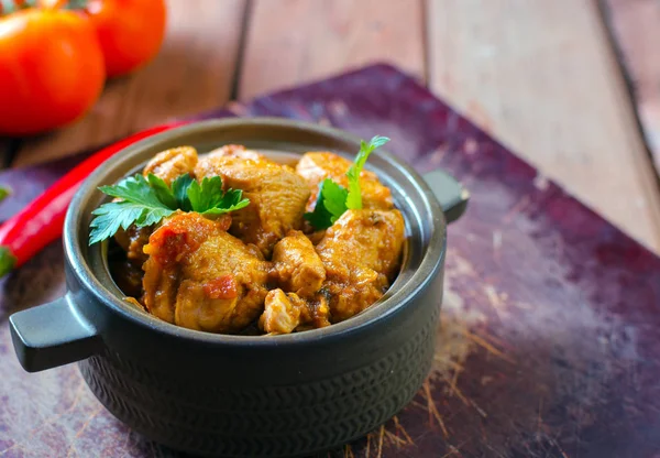 Fresh homemade chicken curry with chilly in vintage ceramic bowl. Selective focus.