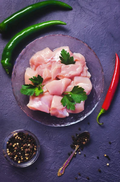 Karanlık taş tablo kase çiğ tavuk küpleri. Meme küpleri. Üstten görünüm. Uzay kopyalayın. Seçici odak.