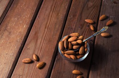 Badem taneli ahşap zemin üzerinde bir cam kabın içinde. Seçici odak.