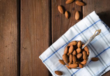 Badem taneli ahşap zemin üzerinde bir cam kabın içinde. Üstten görünüm.