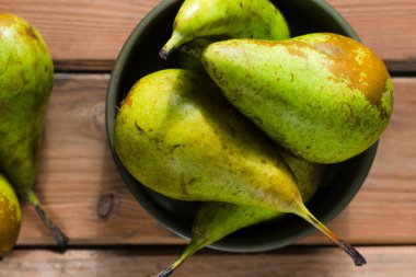 Ahşap rustik arka plan üzerinde bir kapta sulu taze armut konferans