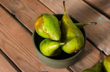 Ahşap rustik arka plan üzerinde bir kapta sulu taze armut konferans