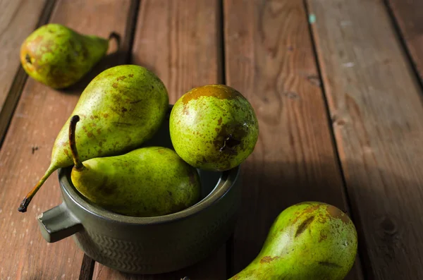 Ahşap rustik arka plan üzerinde bir kapta sulu taze armut konferans. Seçici odak. Kopya alanı.