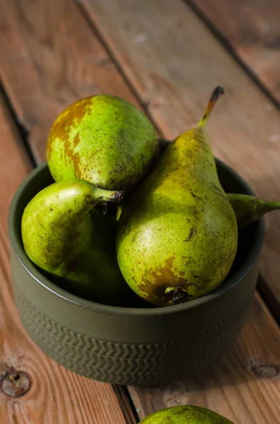 Ahşap rustik arka plan üzerinde bir kapta sulu taze armut konferans