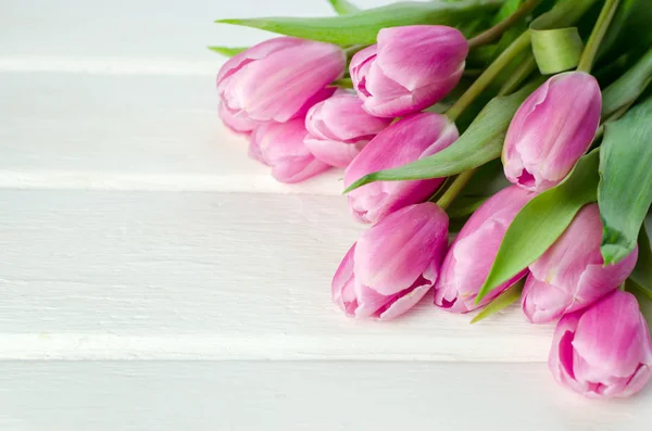 Fila de tulipanes rosados sobre un fondo de madera blanca con espacio para el texto. Fondo de flores festivas para un Día de las Madres u otra celebración — Foto de Stock