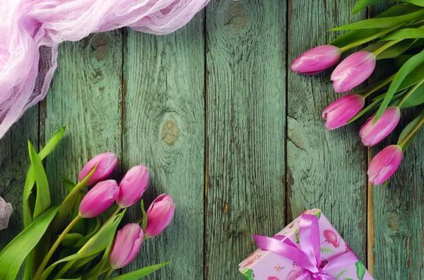 Fila de tulipanes rosados sobre un fondo azul con espacio para el texto. Fondo de flores festivas para el Día de la Madre u otra celebración . — Foto de Stock